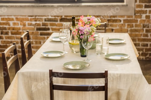 Preview: selective focus of table served with wine glasses, empty plates and bottle of wine for dinner