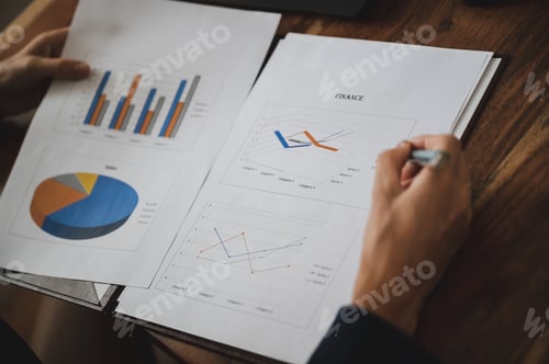 Vista previa: Over the shoulder view of a businesswoman reviewing business and economic report