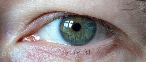 Preview: Macro shot of a blue eye of a person with yellow color in the middle