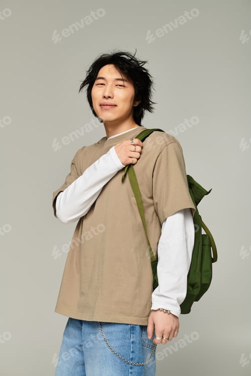 Preview: Stylish young asian man in modern urban attire posing with confidence and charisma