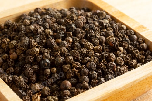 Preview: black peppercorn in wooden plate close up