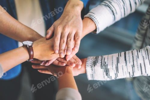 Preview: Top view image of people putting their hands in stack together