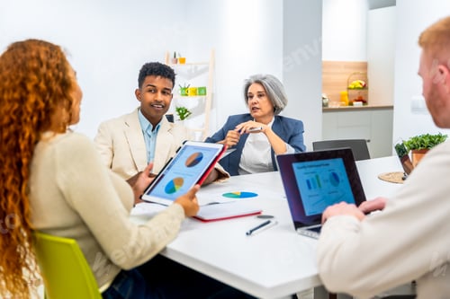 Preview: Diverse business team analyzing data during office meeting