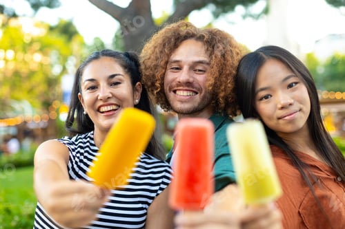 Preview: Happy multiethnic friends showing ice creams at summer festival