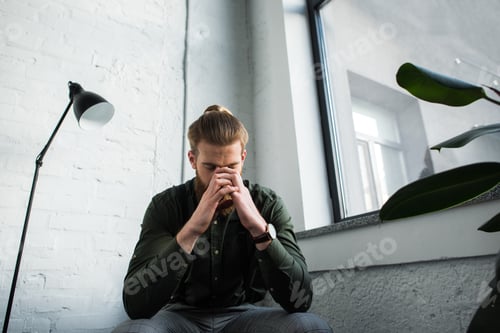 Preview: tired businessman leaning head on hands