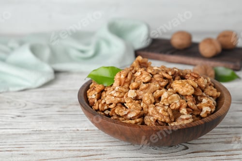 Preview: Plate with tasty walnuts on wooden table. Space for text