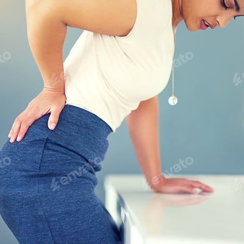 Preview: Cropped shot of a young businesswoman holding her lower back in discomfort