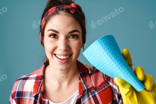 Preview: Happy young woman in gloves smiling and showing washcloth