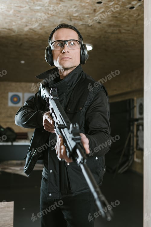 Preview: handsome man with rifle in shooting range
