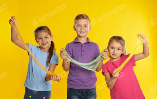Preview: Happy children with slime on yellow background