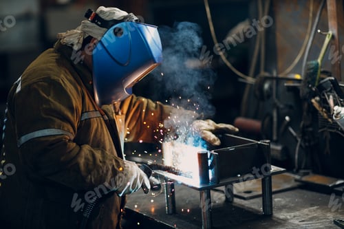 Preview: Welder welding metal steel industrial part construction on factory
