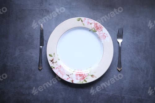 Preview: cutlery and empty plate on black background top down