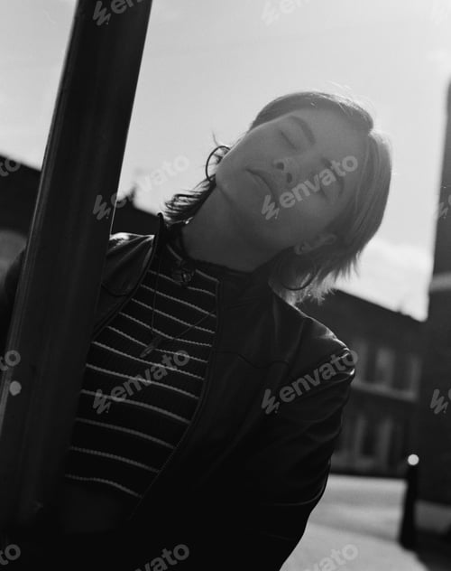 Preview: Analog image of young woman posing around a street light.