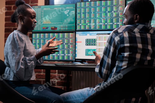 Preview: Investment company professional traders sitting at multi monitor workstation