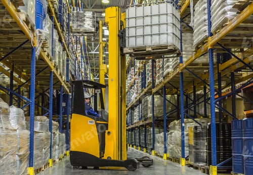 Preview: Warehouse worker on stacker loading cargo on shelf