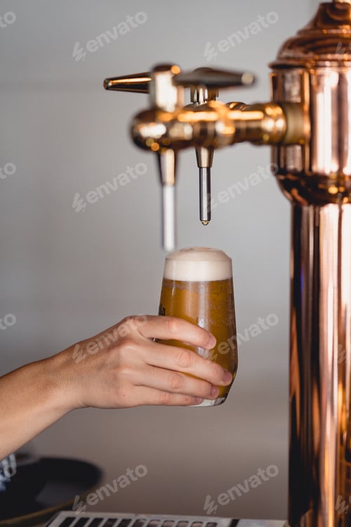 Preview: Vertical shot of a person filling the glass with beer