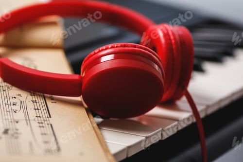 Preview: Sheet music and red headphones on the piano keys