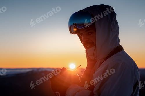 Preview: a man in snowboarding gear holding something in his hands