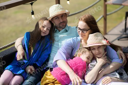 Visualização: Família feliz - mãe, pai e filha de três filhos relaxa no terraço ao ar livre restaurante de verão