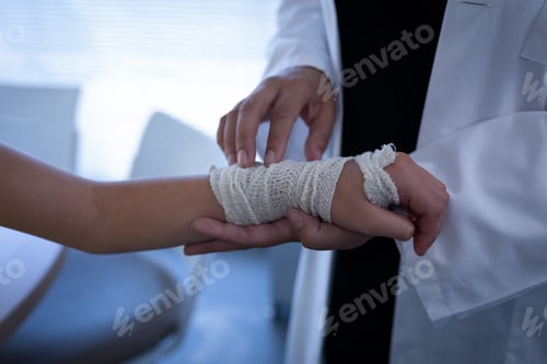 Preview: Close up of matured mixed race female doctor examining Caucasian girl hand in clinic at hospital
