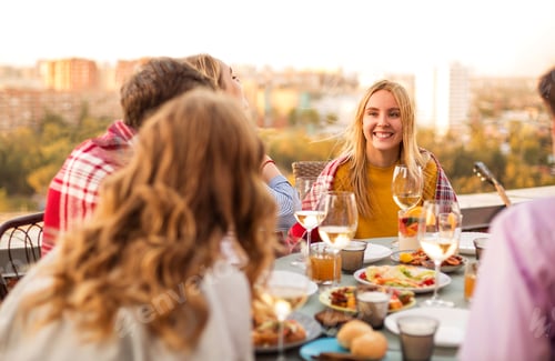 Preview: Cheerful friends drinking white wine during roof party