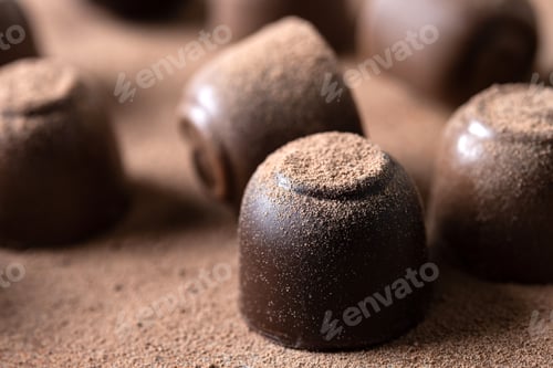 Preview: Chocolate bonbons and cocoa powder background