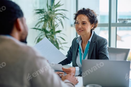Preview: Happy bank manager having a meeting with her clients in the office.
