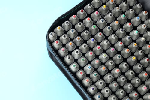 Preview: Many colorful markers in bag on light blue background, top view. Space for text