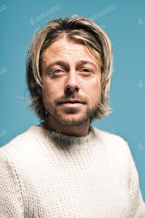 Preview: Young Man With Long Blond Hair With Expressive Face. Light Blue Background.