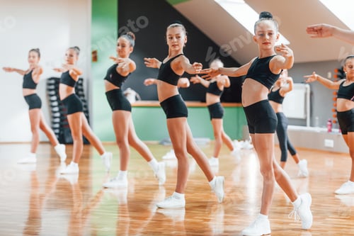 Preview: Group of female kids practicing athletic exercises together indoors
