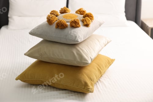 Preview: Stack of soft pillows and bedsheet on bed at home
