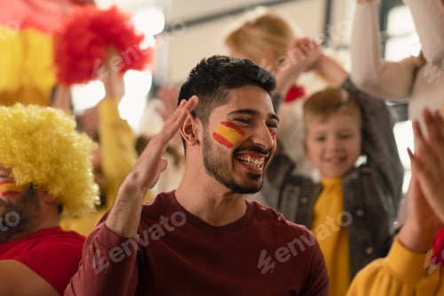 Preview: Excited, happy football fans supproting spanish national team in live soccer match at stadium.