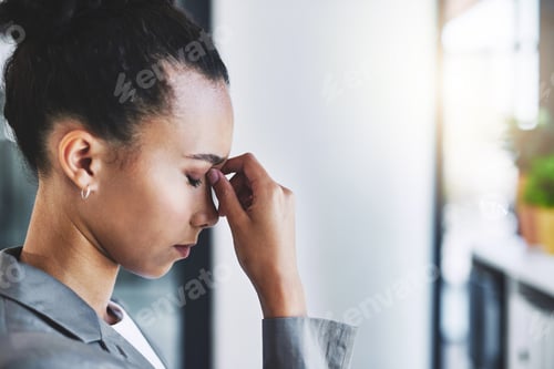 Preview: Cropped shot of an attractive young businesswoman experiencing a headache in her office
