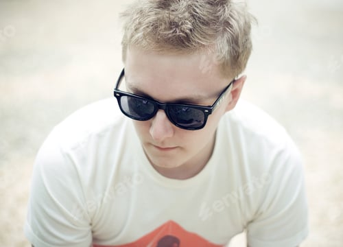 Preview: Stylish Young Man in Sunglasses Looking Downward