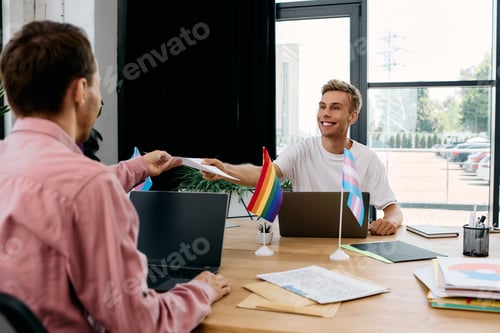 Preview: A handsome gay couple sharing a moment over documents in a vibrant workspace setting