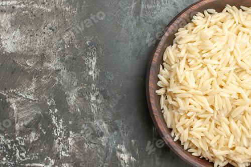 Preview: Half shot of cooked rice in a brown wooden pot on the right side on gray background high resolution