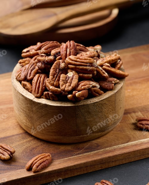 Preview: Shelled pecans in a round wooden plate