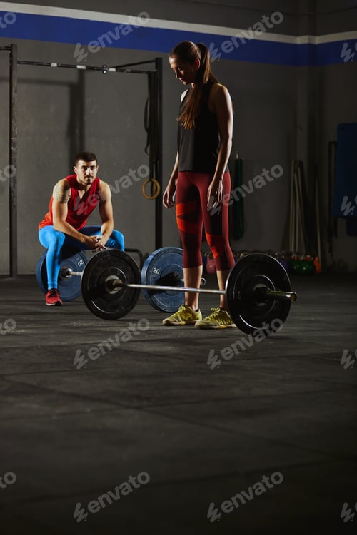 Preview: Woman squatting and lifting a barbell.