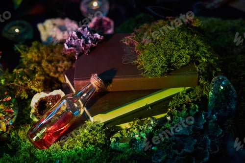 Preview: dark surface features two stacked books topped with colorful moss and crystals