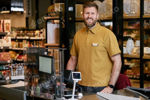 Preview: Smiling Cashier Standing at Supermarket Checkout Counter