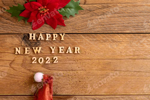 Visualização: Feliz Ano Novo 2022. Citação feita de letras e números de madeira 2022 em fundo de madeira com papai noel