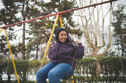 Preview: portrait of african woman playing with swing outdoor in winter day