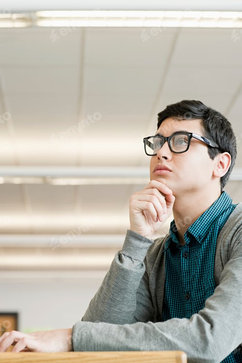 Preview: Contemplative student lost in thought during a class lecture.