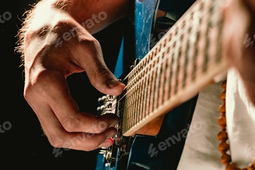 Preview: Close up of male hand playing electric guitar in the dark
