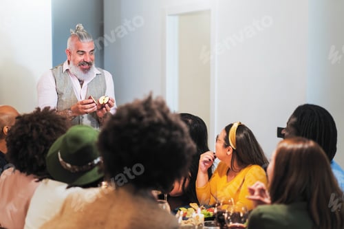 Visualização: Homem barbudo hipster com maçã conversando com amigos jantando na cozinha
