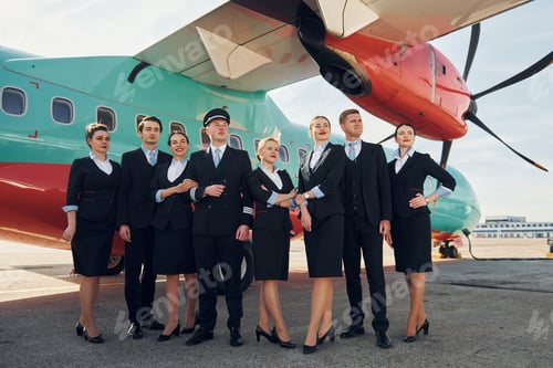 Preview: Near plane. Crew of airport workers in formal clothes standing outdoors together