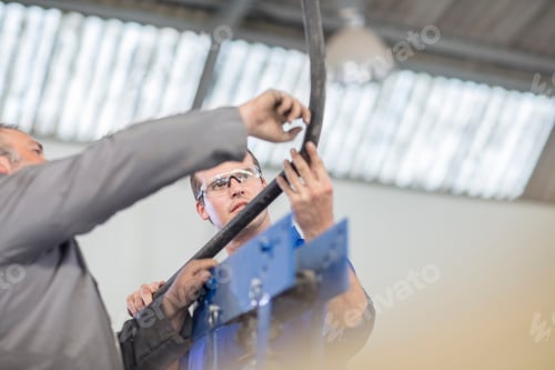 Preview: Two men examining a mechanical part