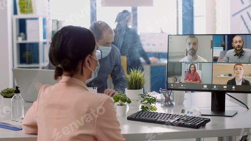 Preview: Businesswoman having online videocall conference wearing medical face mask