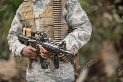 Preview: Mid section of military soldier holding a rifle