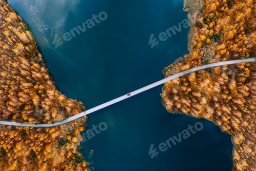 Preview: Aerial view of bridge road with car over blue water lake or sea and autumn color woods in Finland.